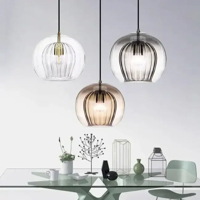 Elegant glass pendant lights hanging over a modern table setting, offering a stylish blend of comfort and design for any home.