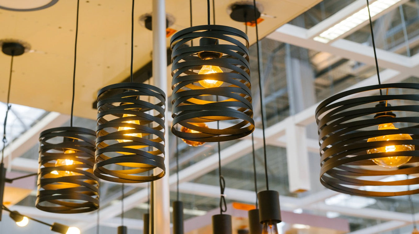 Modern spiral pendant lights with warm glow from the Enchanted Pendant Light Collection hanging in a stylish interior setting.