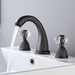 Elegant widespread basin mixer faucet with dual handles, flowing water, featuring antique charm and modern functionality.