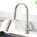 Modern kitchen faucet with swivel spout and pull-out sprayer, polished chrome finish, solid brass construction, in a stylish kitchen setting.