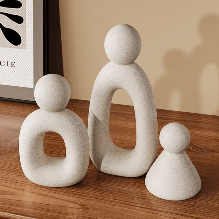 Modern abstract family sculpture set in Nordic style on wooden table.