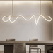 Modern Pencil LED Pendant Chandelier with minimalist scribble design illuminating a dining area.