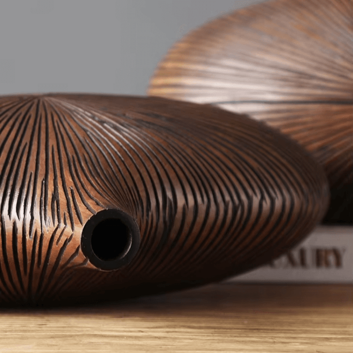 Modern stripe resin wood vase with intricate line patterns on wooden table.