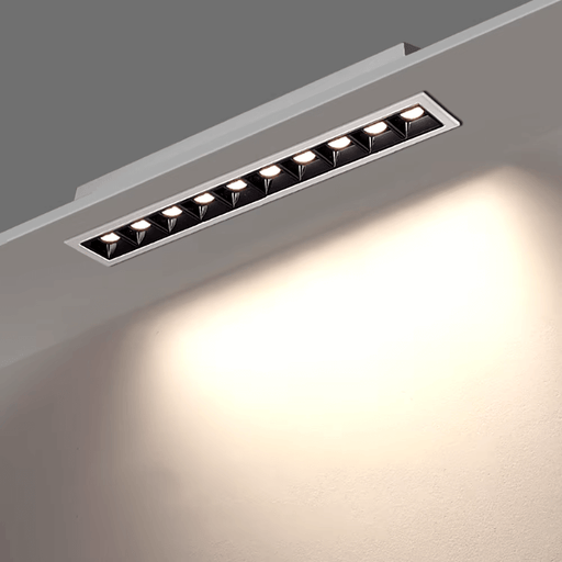 Dimmable LED grille downlight fixture installed in a ceiling, emitting warm light, showcasing sleek design and efficient illumination.