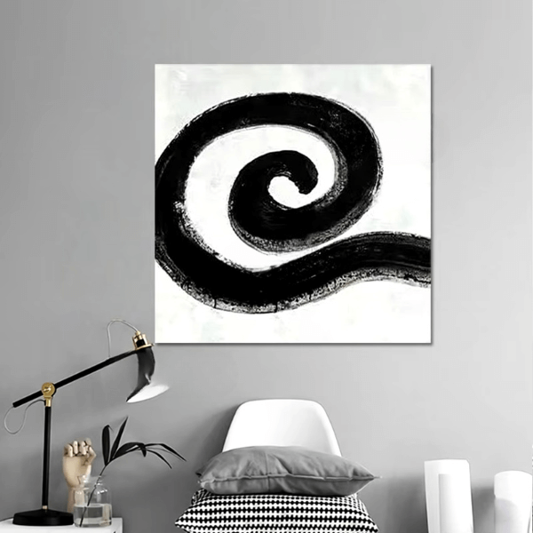 Monochrome spiral abstract canvas art with bold black circle pattern on a wall above modern decor in a minimalist room.