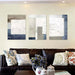 Modern abstract canvas art set in neutral tones above a sofa in a stylish living room setting.