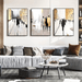 Urban Silhouette Trio Canvas Paintings featuring abstract city life scenes in black, white, and gold, displayed in a modern living room.