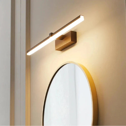 Modern waterproof LED wall light illuminating a bathroom mirror with a sleek gold finish for stylish and functional interior lighting.