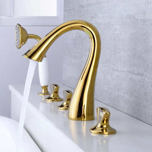 Brushed gold Roman tub filler set with arched spout and hand shower in a modern bathroom.