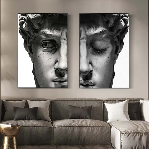 Black and white canvas paintings of Michelangelo's David, adding elegance to a modern living room with a gray sofa and pillows.