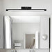 Sleek LED Vanity Mirror Light in minimalist modern bathroom setting, providing bright illumination with black aluminum body.