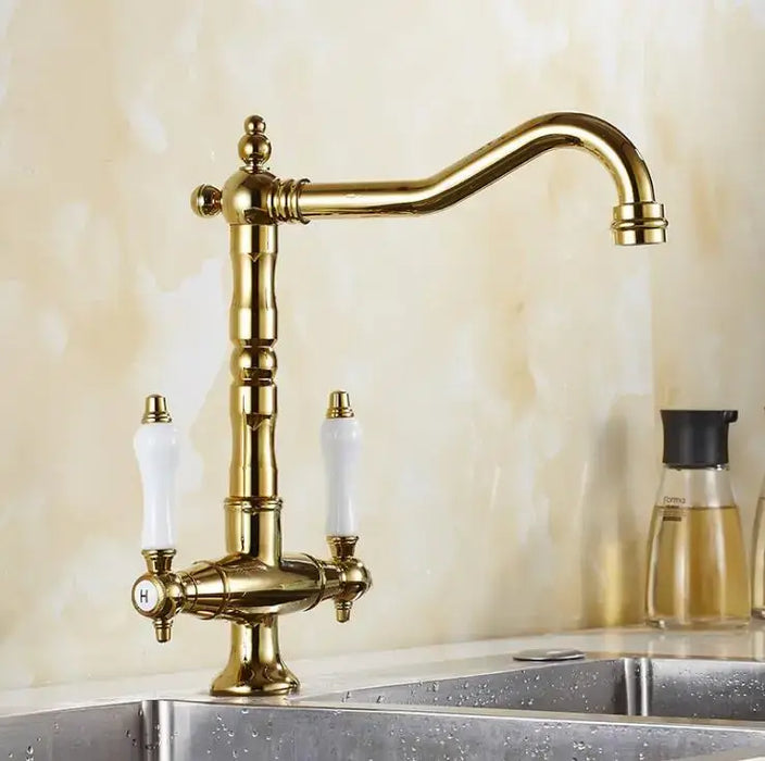 Classic brass swivel kitchen mixer tap with dual handles and 360-degree spout, installed on a modern countertop sink.