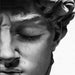 Close-up of Michelangelo's David sculpture on black and white canvas, highlighting intricate details and timeless elegance.