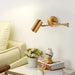 Nordic Foldable LED Wall Lamp in modern living room setting, mounted on wall above side table with books and flowers.