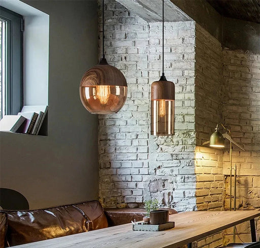 Modern wood color LED pendant light fixtures in a stylish room with brick walls and cozy seating area.