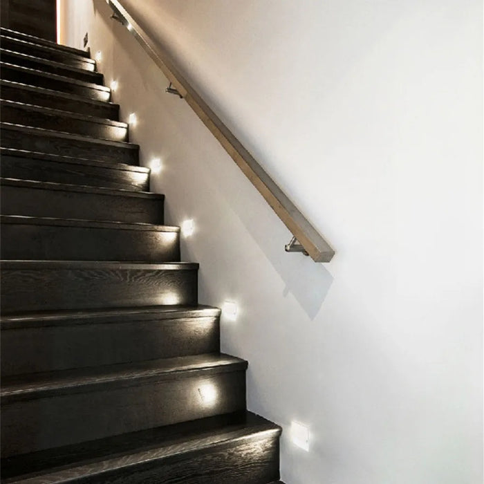 Modern LED recessed footlights illuminating a staircase, showcasing a sleek and contemporary design for pathways or hallways.