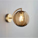 Nordic Glass Ball Wall Lamp with modern design, gold fixture, and illuminated bulb, perfect for elegant and contemporary interiors.