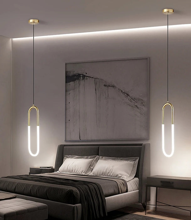 Minimalist U-shaped bar chandelier in modern bedroom setting with polished chrome finish and LED lighting.