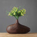 Modern stripe resin wood vase with natural floral arrangement on wooden table, showcasing intricate line patterns and elegant texture.