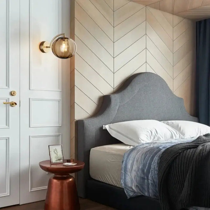 Modern bedroom with Nordic Glass Ball Wall Lamp on herringbone wall, featuring a stylish bed and elegant decor.