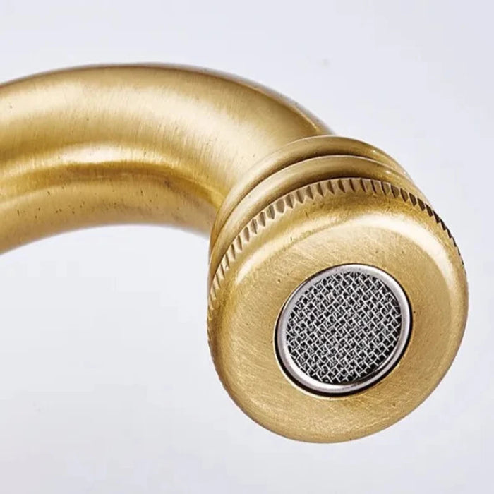 Carved antique brass bathroom faucet spout with intricate details and antique bronze finish.