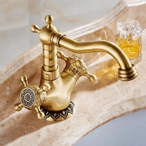 Carved Antique Brass Bathroom Faucet with intricate design and antique bronze finish on marble countertop