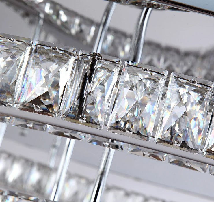 Close-up of modern crystal LED chandelier with elegant square crystals reflecting light.