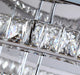 Close-up of modern crystal LED chandelier with elegant square crystals reflecting light.