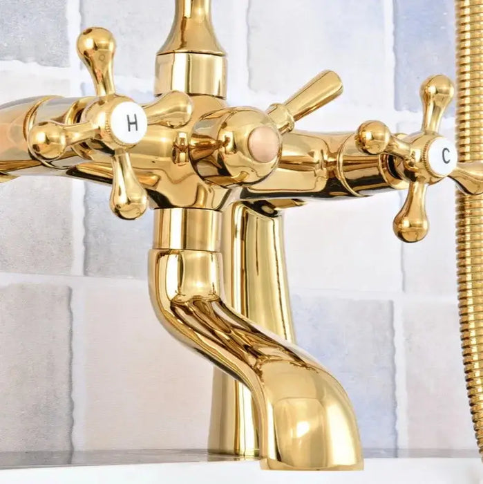 Luxury gold dual-control bathtub faucet with swivel spout and handles against a tiled wall.