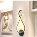 Modern artistic wall lamp with LED light and chic aluminum wood finish, beside a contemporary painting, enhancing home decor.