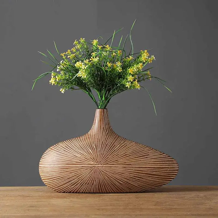 Modern wood-look resin vase with stripe pattern, showcasing yellow and green floral arrangement on wooden tabletop.