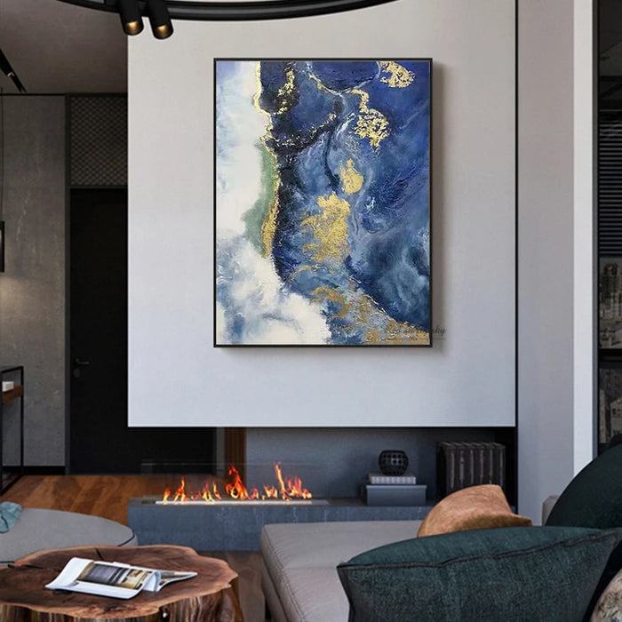 Abstract oil painting "The Blue Ocean" on canvas in modern living room above fireplace, featuring bold blue and gold tones.