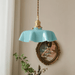 Retro French brass pendant light with scalloped blue shade hanging in vintage-inspired room.