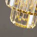 Close-up of tiered crystal glass pendant light with gold accents, showcasing elegant multi-layered design and luxurious detail.