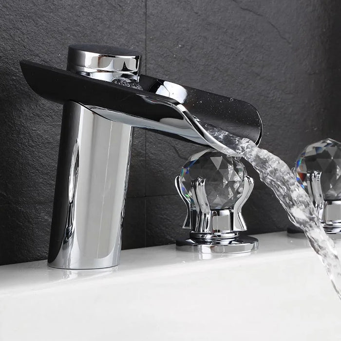 Classic brass waterfall bathtub faucet with crystal handles, featuring a wide spout for smooth water flow and elegant design.