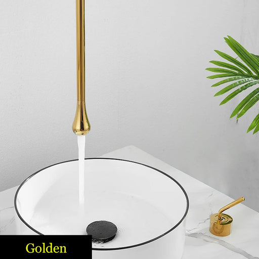 Golden Water Drop Hang Ceiling Faucet in bathroom setting with water flowing into white basin.