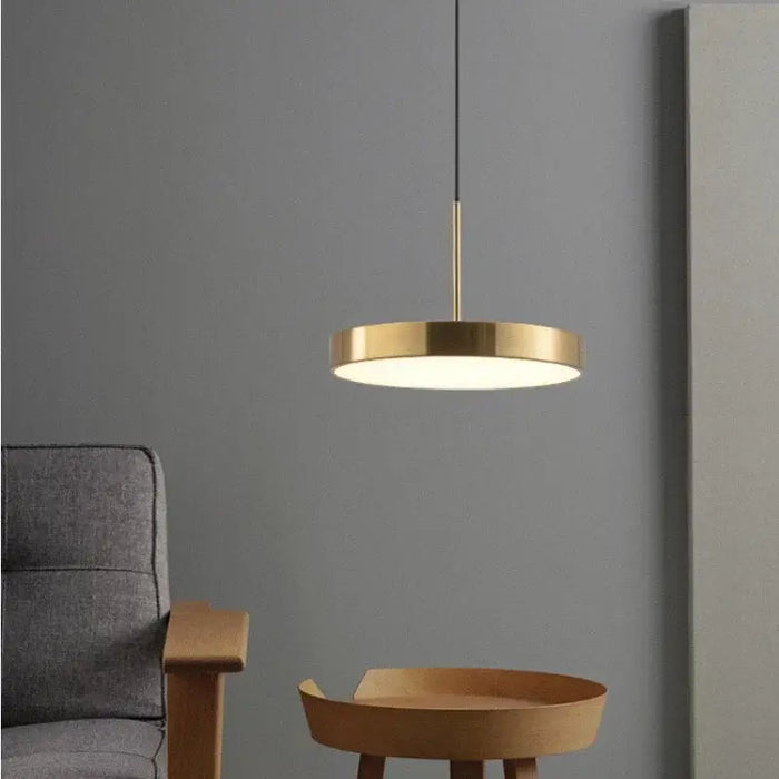 Modern LED saucer pendant light in contemporary living room setting with sleek gray walls and wooden furniture.