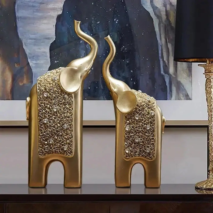 Gold resin elephant decor set on a table in front of a painted artwork.