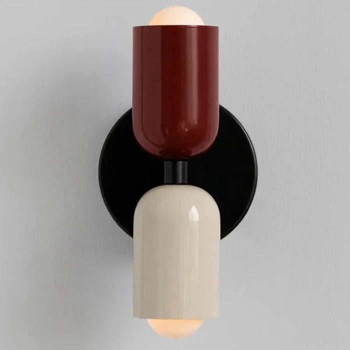 Colorful bedside wall lamp with modern metal design, featuring red and white hues against a black circular base.