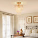 Elegant three-tier crystal ceiling chandelier in a cozy bedroom setting.