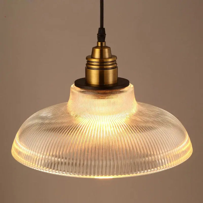 Vintage glass stripe pendant light with brass finish, featuring textured round shade for ambient glow in dining areas and kitchens.