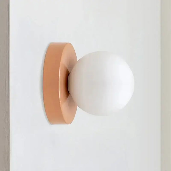 Modern LED wall sconce with frosted glass globe in minimalist design, ideal for cozy lighting in bedrooms and hallways.