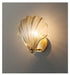 Modern luxury brass shell wall lamp with clear glass shade, elegant lighting fixture for home decor.