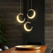 Elegant adjustable crescent moon chandelier illuminating a modern dining space with celestial charm and sleek design.