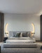 Modern bedroom with elegant line wall lights above a contemporary bed setting.