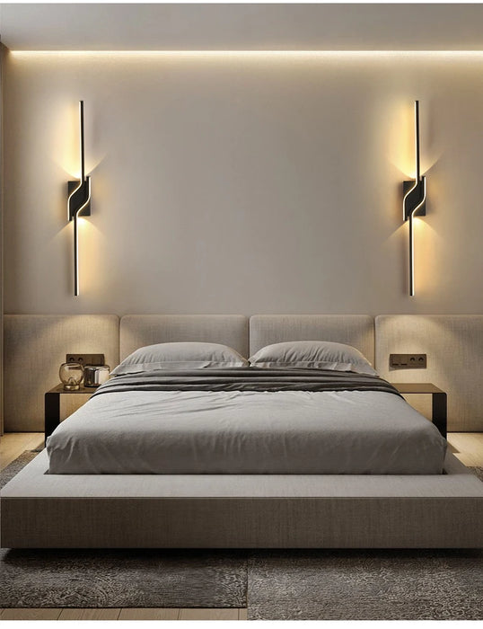 Modern minimalist vertical-horizontal LED wall sconce illuminating a stylish bedroom with a sleek bed and elegant decor.