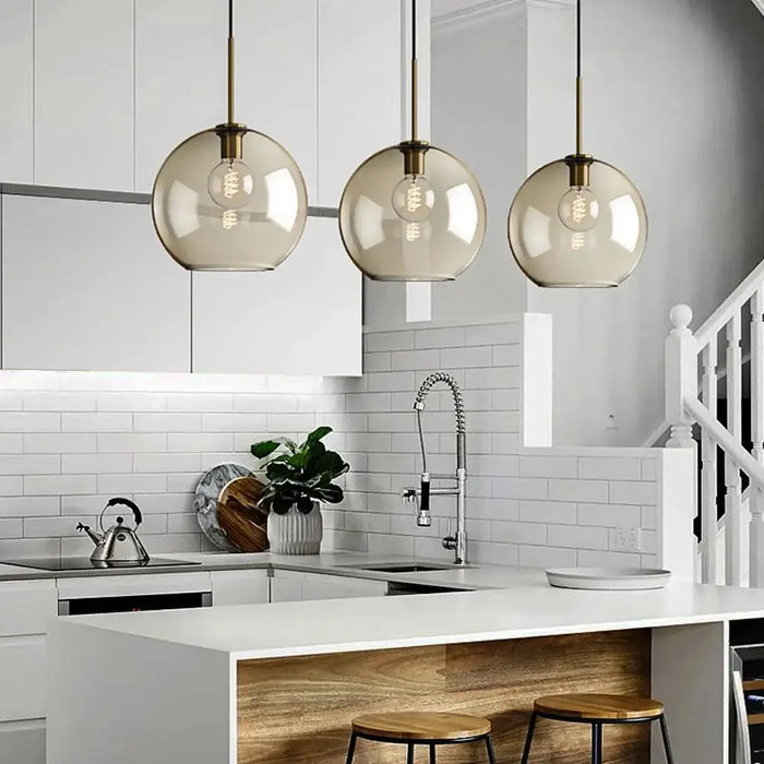 Modern industrial glass pendant lamps in elegant kitchen setting with minimalist design.