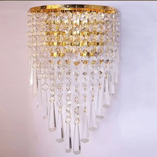 Elegant crystal wall sconce with gold accents, featuring cascading clear crystals for luxurious home decor lighting.