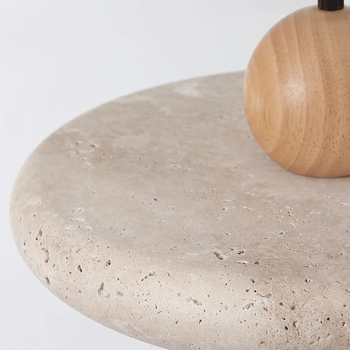 Close-up of a light yellow travertine stone surface with a wooden base, showcasing the natural texture and aesthetic of the material.