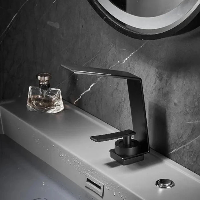 Ultra-thin black waterfall basin faucet with sleek design on modern bathroom sink.